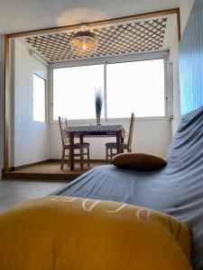 a bedroom with a bed and a table with chairs at LE COCON DE LA MARINA in Leucate