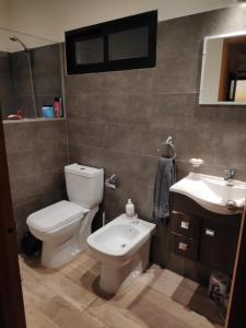 a bathroom with a toilet and a sink at Cabaña El Trisquel in Villa Serrana +30 photos