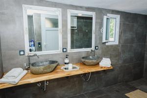 two sinks in a bathroom with two mirrors at Villa Angelos in Ermioni