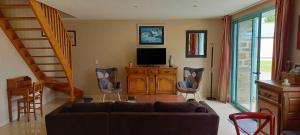 a living room with a couch and a television at Gite Couesnon in Roz-sur-Couesnon