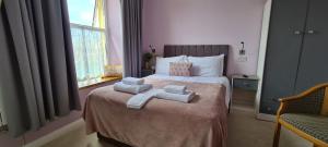 a bedroom with a bed with towels on it at Torland Seafront Hotel - all rooms en-suite, free parking, wifi in Paignton