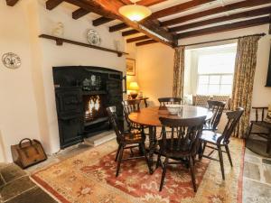 a dining room with a table and a fireplace at Cowstonegill in Bradley