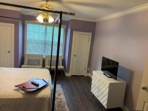 a bedroom with a bed and a tv on a cabinet at Huffman House Bed & Breakfast in Minden