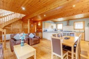 a kitchen and living room with a wooden ceiling at Jamaal Lodge in Hadston