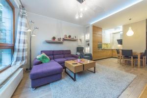 a living room with a purple couch and a table at Pomorskie Apartamenty Aquarius in Sopot