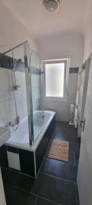 bagno con doccia, vasca e lavandino di B&R Apartment in Humboldtstraße a Norimberga