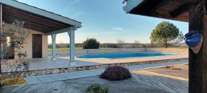 un patio trasero con piscina y pabellón en REMOTELY HAVEN near Eymet studio gite with shared pool & private garden for peaceful holiday or remote working!, en Eymet