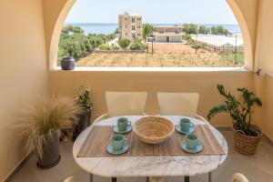 a table and chairs in a room with a large window at Eden of grameno Luxury sea view apartment in Palaiochóra