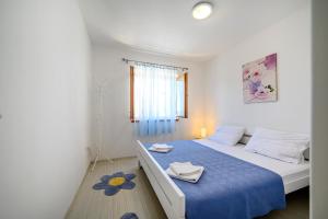 a small bedroom with a bed with a blue bedspread at Holiday Home Andrea in Primošten