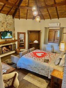 a bedroom with a large bed and a fireplace at Pousada Villa D'Encanto in Monte Verde