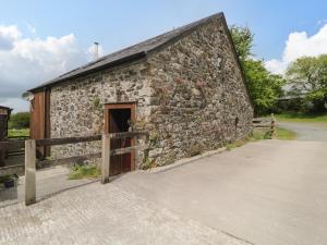 an old stone building with a wooden door at Meader Barn in Marytavy