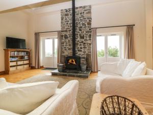 a living room with two couches and a fireplace at Meader Barn in Marytavy
