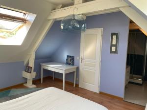 a bedroom with a white bed and a table at Les Oiseaux de Passage in Gignac