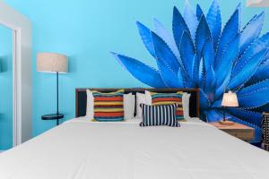 a bedroom with a bed with a blue wall at The Paloma Resort in Palm Springs