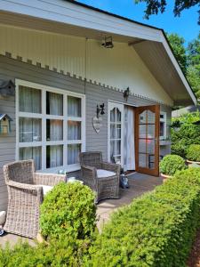 a patio with wicker chairs on a house at Charme chalet in Zutendaal