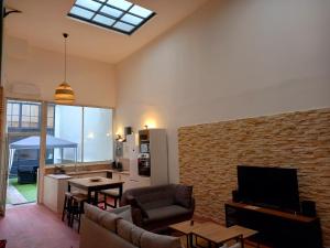 a living room with a couch and a tv and a kitchen at T5 L'ATELIER in Valence-dʼAgen