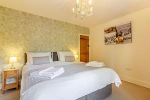 a bedroom with a large white bed with a chandelier at 34 Church Street in Matlock