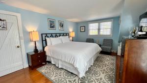 a bedroom with a white bed and blue walls at Dragonfly Guest House in Ogunquit