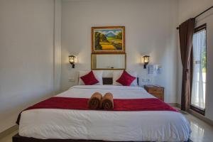 a bedroom with a bed with two pairs of shoes on it at L Degus Hostel in Nusa Penida