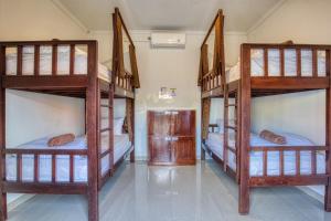 a bedroom with three bunk beds in a room at L Degus Hostel in Nusa Penida