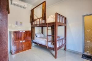 um quarto com 2 beliches e um espelho em L Degus Hostel em Nusa Penida