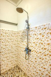 een douche in een badkamer met bloemen aan de muur bij L Degus Hostel in Nusa Penida