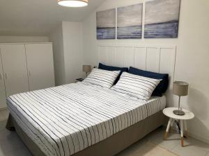 1 dormitorio con 1 cama con edredón azul y blanco en La Casa BluMare, en Porto Recanati