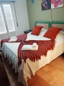 a bedroom with a large bed with white sheets and red pillows at lagos central hostel in Lagos