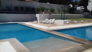 a swimming pool with two lounge chairs next to it at Aldeia das Açoteias, Apartment, WI-FI, in Albufeira