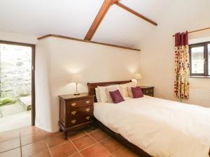 a bedroom with a bed and a window at Nestling Barn in Marytavy