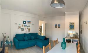 een woonkamer met een blauwe bank en een tafel bij Sun & Sea rooftop in Costa da Caparica +16 foto's