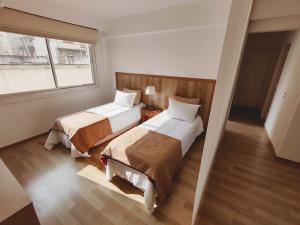 a hotel room with two beds and a window at Precioso departamento en el centro de la ciudad in Buenos Aires