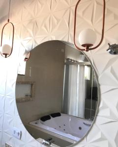 a mirror in a bathroom with a bath tub at EL SHADDAY HOTEL in Diamante do Norte
