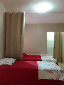 a bedroom with two beds and a window at Menina da Lua in Rio das Ostras
