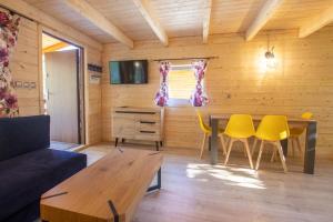 a living room with a table and yellow chairs at Domek in Szklarska Poręba