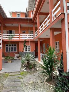 an orange building with plants in the courtyard at Menina da Lua in Rio das Ostras