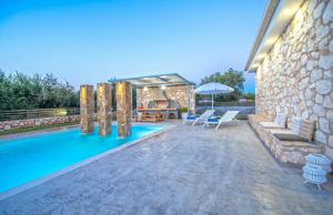 a patio with a swimming pool and a house at Villa Dionisis in Laganas