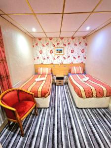 a small room with two beds and a chair at The Albany Hotel in Blackpool