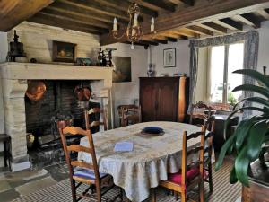 comedor con mesa y chimenea en Ferme fortifiée d Enguenard, en Formigny