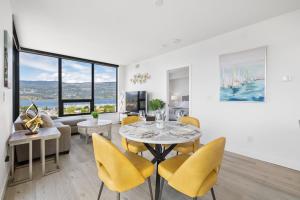 a dining room with a table and yellow chairs at Brand New Luxury Downtown Near the Beach #13 in Kelowna