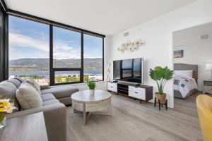 a living room with a couch and a bed and a television at Brand New Luxury Downtown Near the Beach #13 in Kelowna
