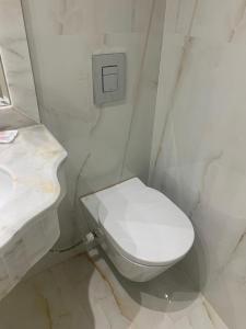 ein Badezimmer mit einem weißen WC und einem Waschbecken in der Unterkunft Abeer Hotel Alexandria in Alexandria