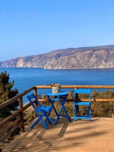 una mesa azul y dos sillas en una terraza con el océano en Carilafquen Habitaciones en Suite, en Valparaíso