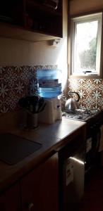 a kitchen counter with a stove and a window at Carilafquen Habitaciones en Suite in Valparaíso