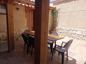 einen Holztisch und Stühle auf einer Terrasse in der Unterkunft El Balcon de Peñafiel in Peñafiel