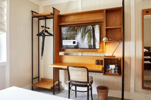 a bedroom with a desk with a chair and a mirror at Life House, South of Fifth in Miami Beach