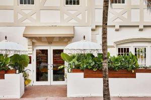 a white building with potted plants in front of it at Life House, South of Fifth in Miami Beach