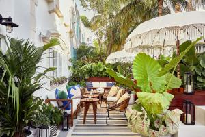 um pátio exterior com plantas, mesas e cadeiras em Life House, South of Fifth em Miami Beach