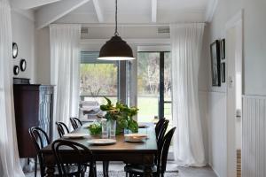 uma sala de jantar com uma mesa com cadeiras e uma grande janela em Maple Tree House em Musk Vale