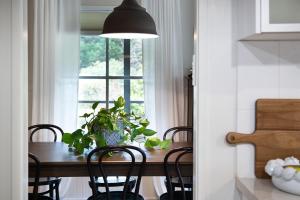 uma mesa de jantar com cadeiras e uma janela em Maple Tree House em Musk Vale